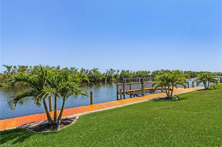 Dock area with a lawn, a water view, and boat lift