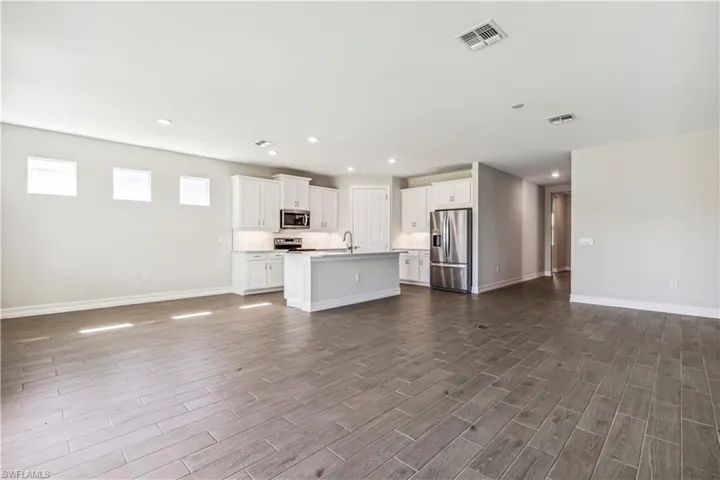 Unfurnished living room with hardwood / wood-style floors and sink