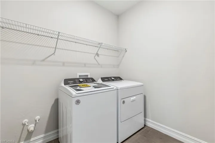 Laundry room with hardwood / wood-style flooring and washer and dryer