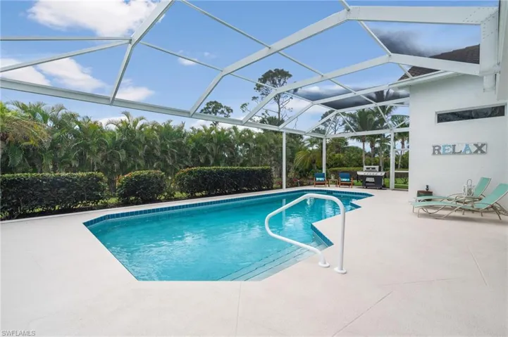 Outdoor pool with a patio area and glass enclosure
