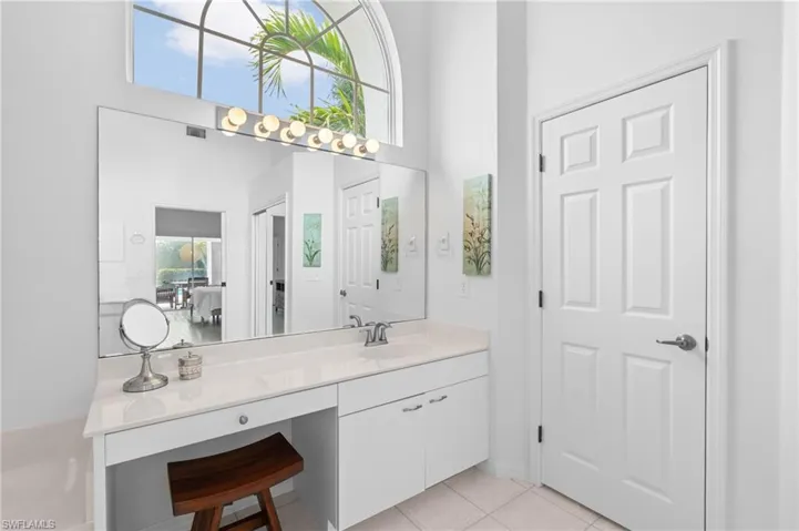 Bathroom featuring visible vents, vanity, a towering ceiling, and tile patterned floors