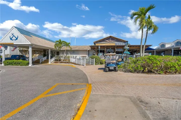 View of building exterior with uncovered parking and fence