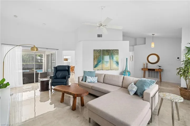 Living area with visible vents, high vaulted ceiling, and ceiling fan
