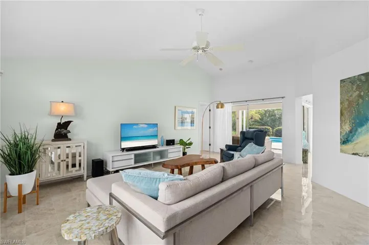 Living room featuring high vaulted ceiling and a ceiling fan