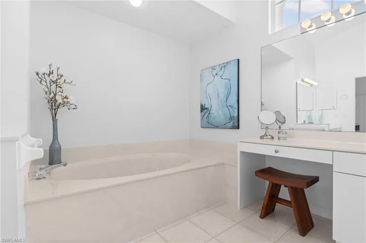 Bathroom with tile patterned flooring, a garden tub, and vanity