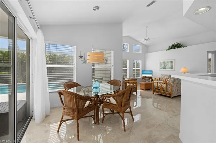 Dining room featuring high vaulted ceiling, visible vents, and a ceiling fan