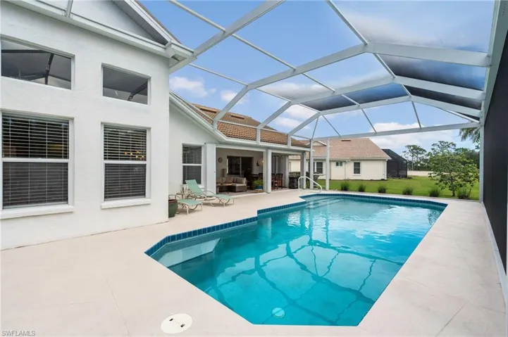 Outdoor pool with a patio and glass enclosure