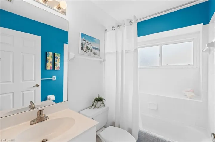 Bathroom with shower / bath combo, vanity, and toilet