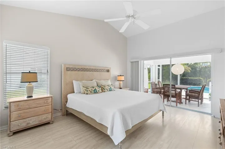 Bedroom with ceiling fan, access to outside, and vaulted ceiling