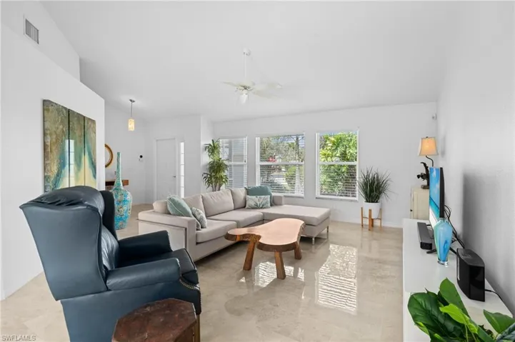 Living room with a ceiling fan, lofted ceiling, and visible vents
