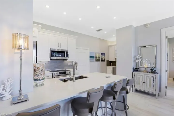 Kitchen featuring stainless steel appliances, a peninsula, visible vents, and a kitchen bar