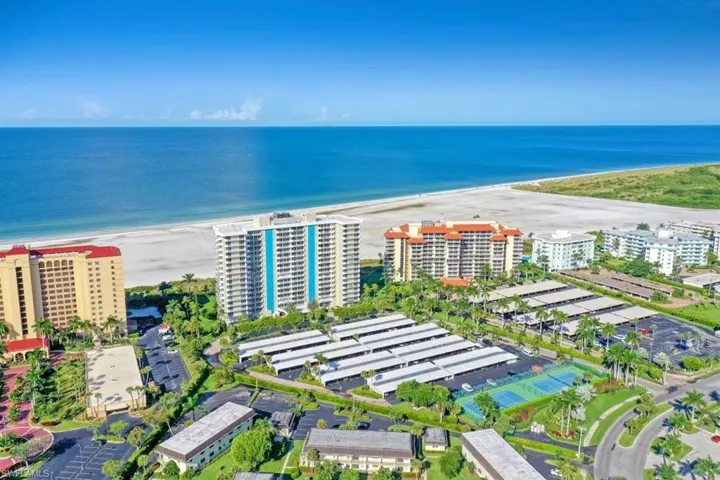 Aerial view featuring a beach view and a water view
