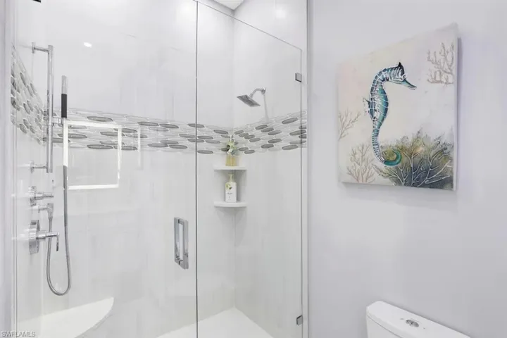 Bathroom with a shower stall and toilet