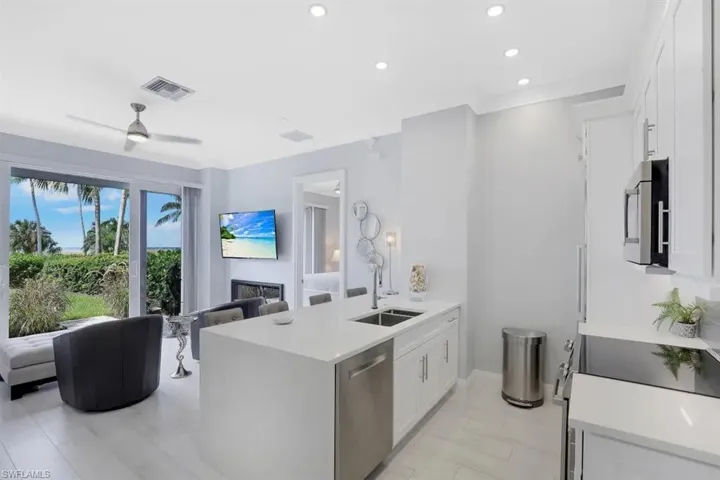 Kitchen with a peninsula, open floor plan, stainless steel appliances, and a sink