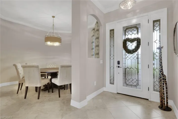 Foyer entrance featuring crown molding and arched walkways