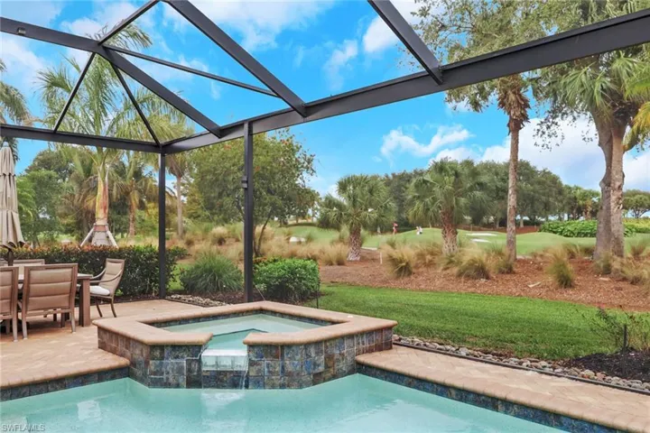 View of pool featuring a lanai, a patio area, a sunroom, view of scattered trees, and a yard