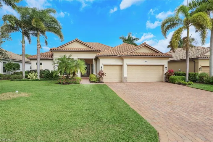 Mediterranean / spanish home with stucco siding, a front yard, decorative driveway, an attached garage, and a tile roof