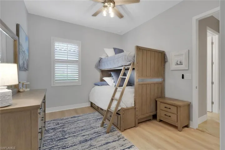 Bedroom with ceiling fan and light wood-style floors