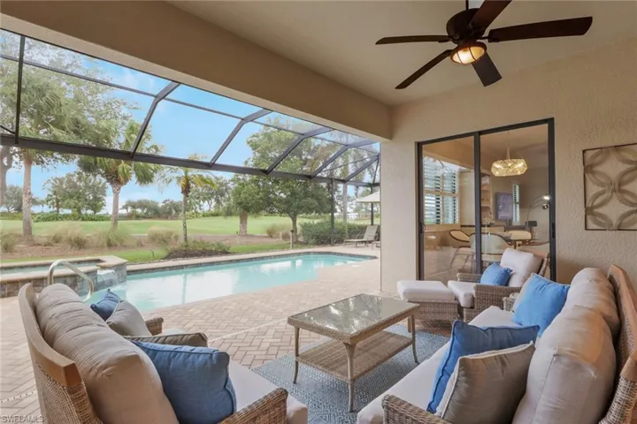 View of swimming pool featuring a patio area, a pool with connected hot tub, glass enclosure, and outdoor lounge area