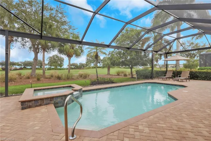 View of swimming pool with glass enclosure, a patio, a pool with connected hot tub, and a sunroom