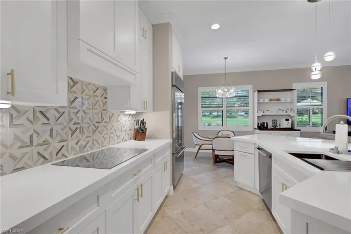 Kitchen with white cabinets, decorative light fixtures, a chandelier, decorative backsplash, and recessed lighting