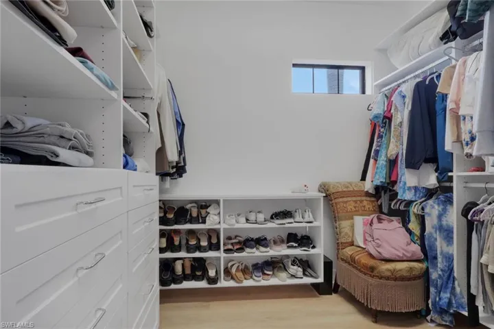 Walk in closet with light wood finished floors