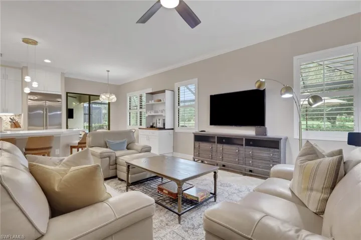 Living room featuring ornamental molding and a ceiling fan