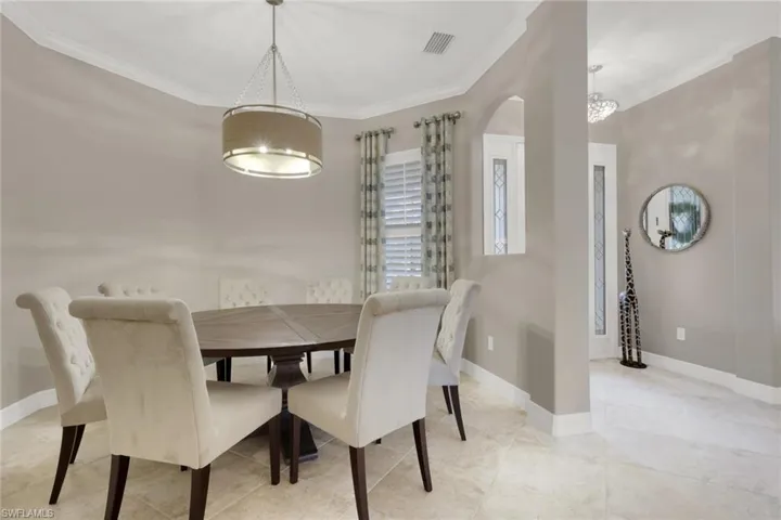 Dining area with crown molding and baseboards