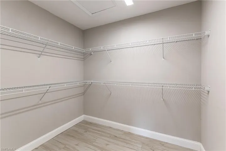 Walk in closet with light wood finished floors