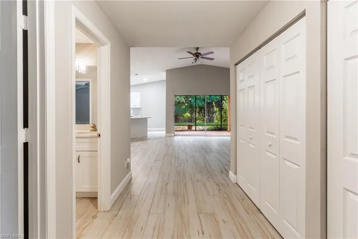 Corridor featuring light wood-style flooring and vaulted ceiling