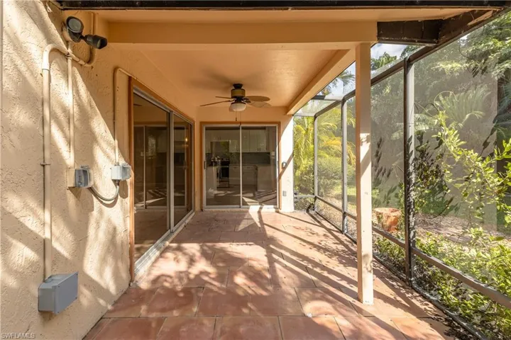 Unfurnished sunroom with a ceiling fan and a patio