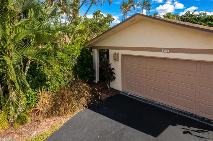 View of front of house with stucco siding, a garage, and driveway