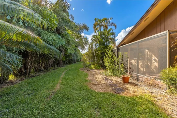 View of green lawn featuring a sunroom