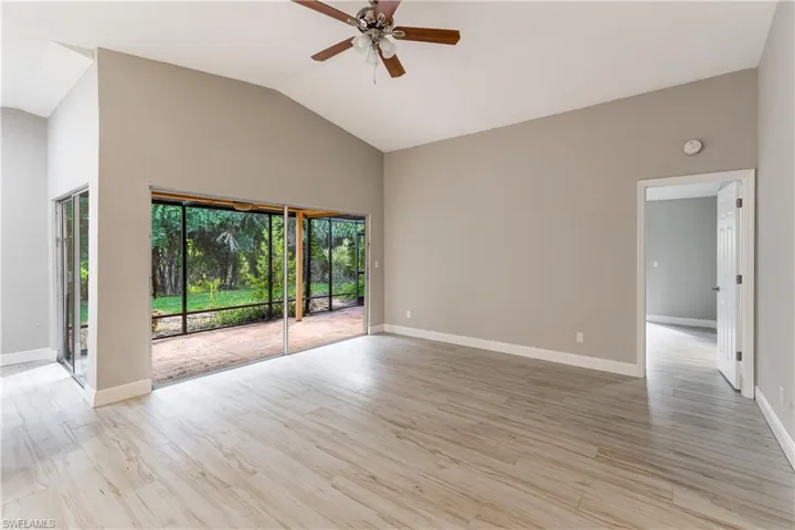 Empty room featuring light wood-style floors, ceiling fan, and high vaulted ceiling