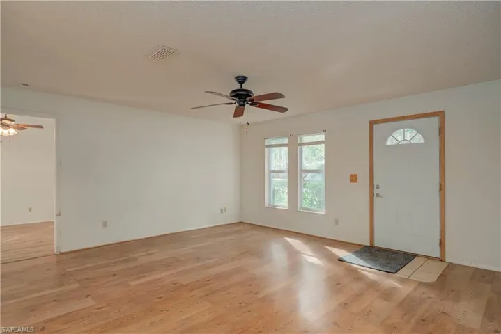 Entrance foyer with a ceiling fan, light wood-style floors, and a textured ceiling