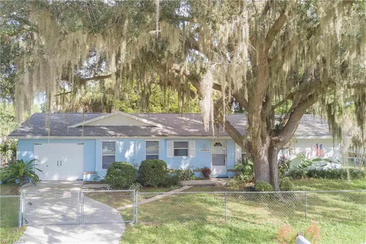 Ranch-style home featuring a fenced front yard, a shingled roof, and a gate