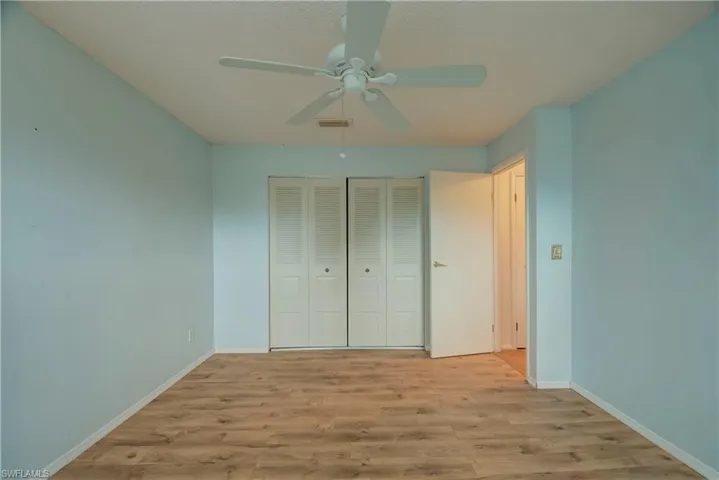 Unfurnished bedroom with light wood finished floors, a closet, a ceiling fan, and a textured ceiling