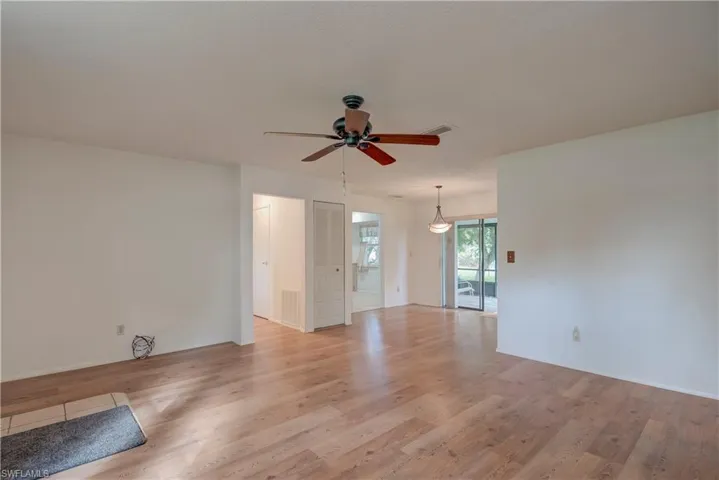 Unfurnished living room with light wood-type flooring and ceiling fan