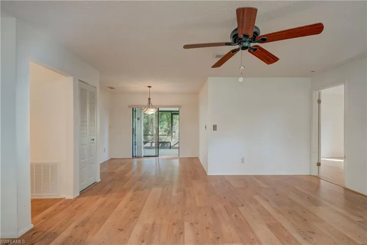 Unfurnished room with light wood-type flooring, ceiling fan, and a textured ceiling