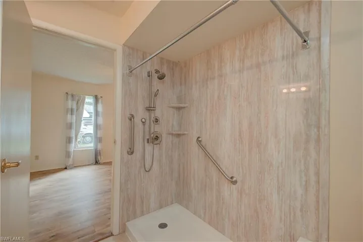 Full bath featuring a shower stall and wood finished floors