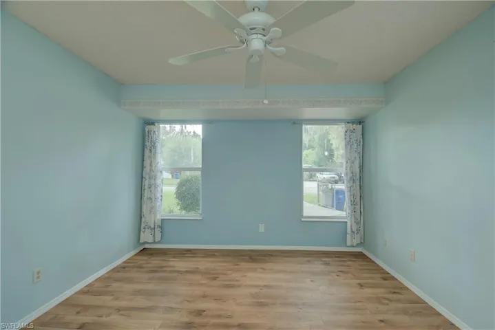 Empty room with healthy amount of natural light, light wood-type flooring, and a ceiling fan