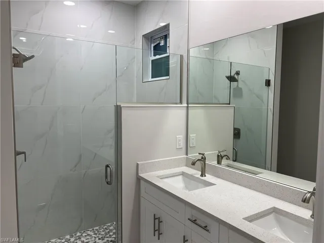 Bathroom featuring double sink vanity and walk in shower