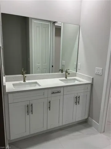 Bathroom featuring tile flooring and double sink vanity