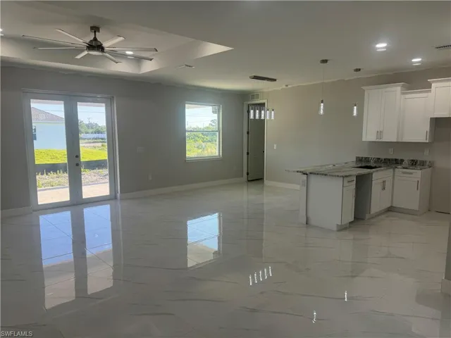 Kitchen featuring a healthy amount of sunlight, white cabinets, ceiling fan, and light tile floors