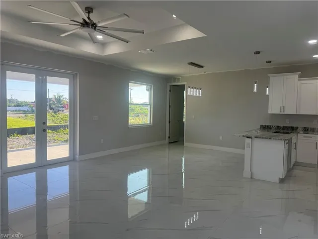 Kitchen with ceiling fan, french doors, decorative light fixtures, and light tile floors