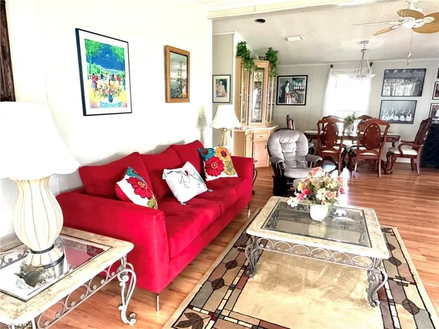 Living room featuring ceiling fan, hardwood / wood-style flooring with sliding door to lanai.