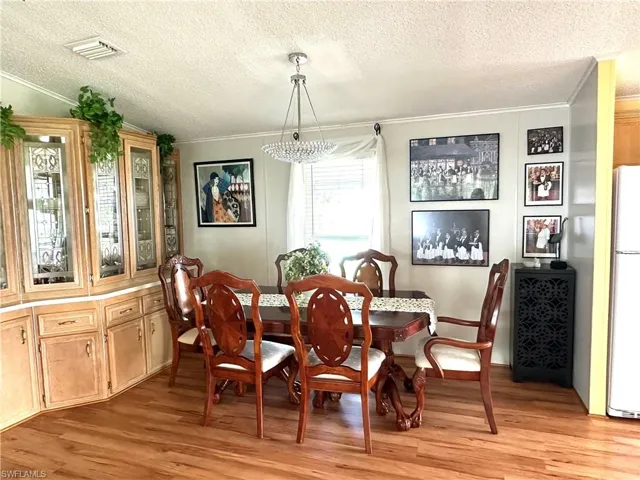 Dining room featuring built in cabinets. Light wood-type flooring and sparkling chandelier.