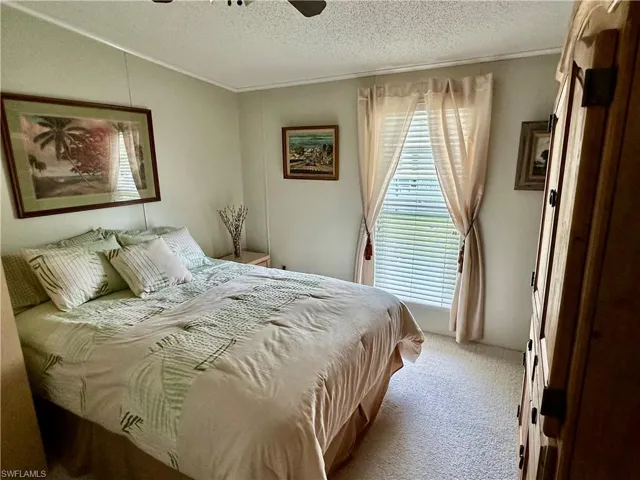 Bedroom with light carpet, and ceiling fan