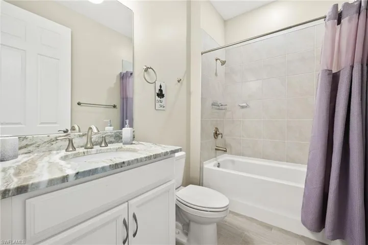 Full bath with vanity, shower / bathtub combination with curtain, and wood finished floors