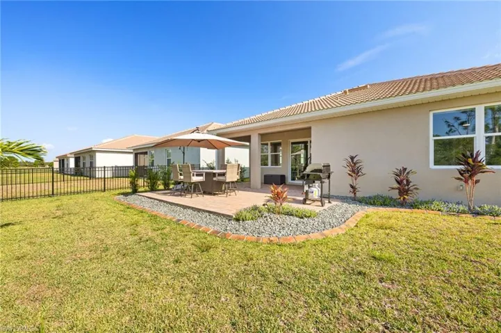 Back of property featuring stucco siding, a tile roof, and a patio